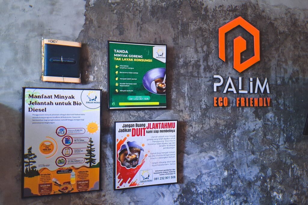 Poster edukasi tentang manfaat jelantah, tanda minyak tak layak konsumsi, dan informasi pembelian jelantah terpasang di dinding Palim Eco Friendly.