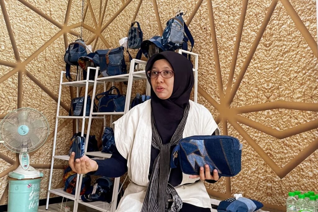 Sari selaku founder D'Belel menunjukkan tas dan dompet dari jeans usang