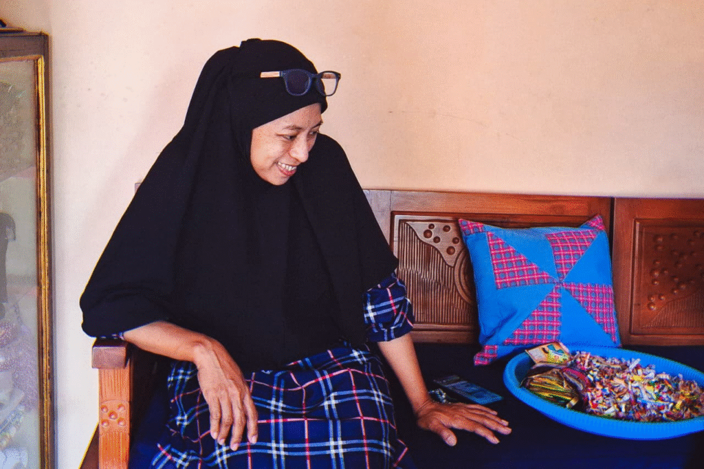 Yustin duduk sambil menunjukkan produk Yust Collection